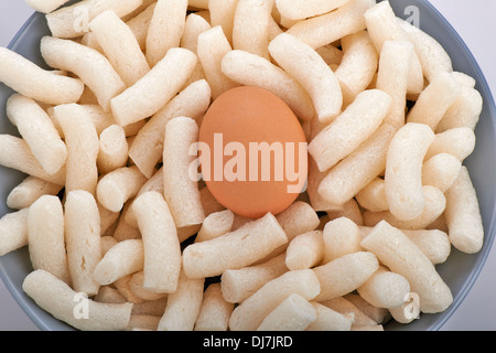 Ciotola con imballaggio noccioline di polistirolo protetto un uovo Foto Stock