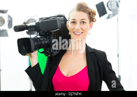 Camerawoman o cameraman o le riprese con una fotocamera digitale sul set di un film o di produzione video per TV o televisione o News Foto Stock