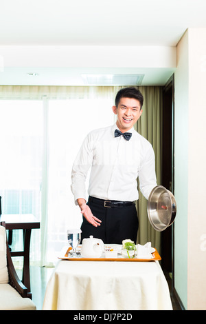 Cinese asiatici servizio in camera Servizio cameriere o steward che servono gli ospiti il cibo in un grand hotel o camera di questo hotel di lusso Foto Stock