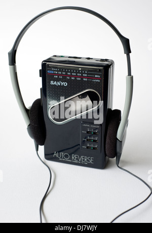 Un vecchio Sanyo WALKMAN a cassetta personale player con radio, insieme con una coppia di cuffie, su sfondo bianco Foto Stock