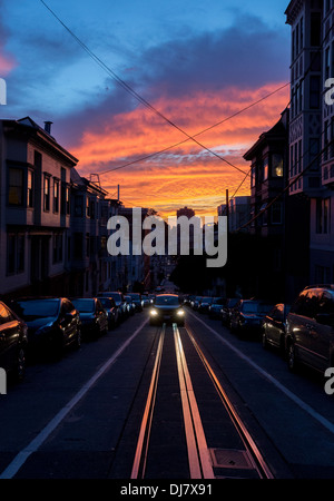 Drammatica arancione e blu Cielo di tramonto sopra il cavo auto le vie di San Francisco. Foto Stock