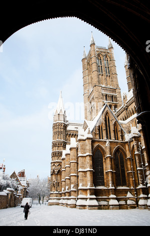 Una persona che cammina in passato la Cattedrale di Lincoln in una fredda giornata invernale e dopo una nevicata Foto Stock