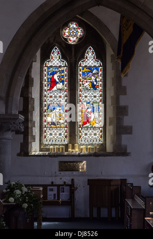 Close up della vetrata della St Edwards Chiesa, Corfe Castle, Dorset, Inghilterra. Candele stand in primo piano. Foto Stock