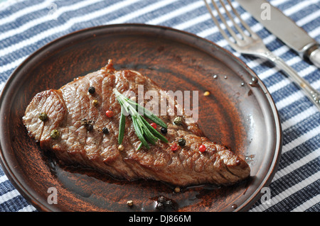 Bistecca alla griglia sulla piastra con spezie e rosmarino closeup Foto Stock