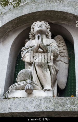 Statua di un angelo che prega nel cimitero Bellu, Bucarest, Romania Foto Stock