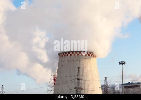 Torre di raffreddamento di generazione di elettricità in stazione con il vapore sul cielo blu sullo sfondo Foto Stock