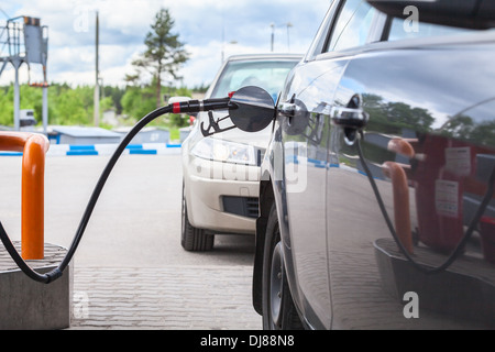 Il riempimento della macchina con benzina presso la stazione di gas Foto Stock