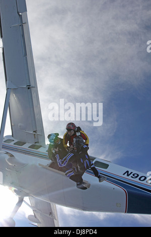 Questo freefly skydiving team saltato fuori di un aeromobile e tenendo le mani insieme. È divertente per tutti a volare libero nel cielo. Foto Stock