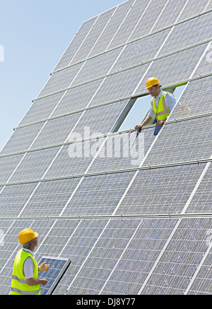 Lavoratori esaminando i pannelli solari Foto Stock