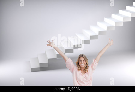 Donna sorridente con le braccia sollevate fino Foto Stock