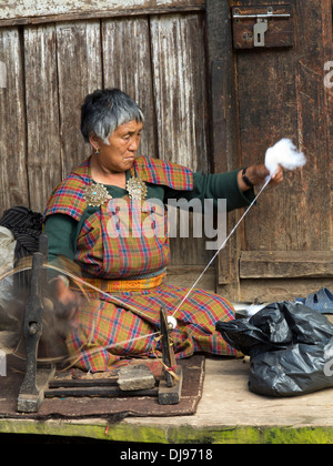 Il Bhutan, Nobding bazaar, donna di filatura capelli di yak a mano sul volante Foto Stock