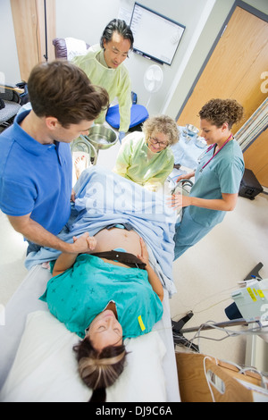 Uomo Donna tenendo la mano durante la consegna in ospedale Foto Stock