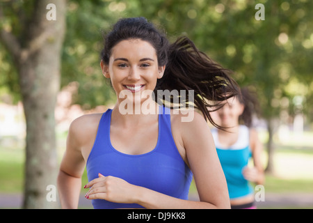 Bella bruna donna in esecuzione in un parco Foto Stock