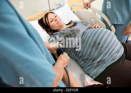 Controllo infermiere della donna incinta, pressione sanguigna Foto Stock