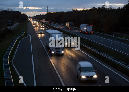 Traffico in autostrada a67 nei Paesi Bassi con le automobili e camion al cadere della notte in direzione della Germania. Foto Stock