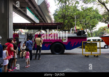 Le persone con i bambini nella parte anteriore del veicolo anfibio utilizzato per il Duck Tour crociera in Singapore, in attesa di tour per avviare Foto Stock