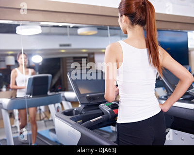 Giovane donna in corsa su tapis roulant Foto Stock