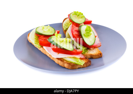 Fette biscottate panini con lattuga, pomodoro, cetriolo e lombo di maiale sulla piastra isolata su sfondo bianco. Foto Stock