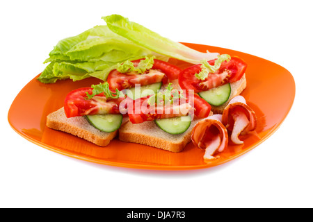 Fette biscottate panini con lattuga, pomodoro, cetriolo e lombo di maiale sulla piastra isolata su sfondo bianco. Foto Stock