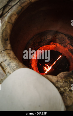 Tradizionale araba flatbread essendo preparato in una fossa di fuoco in un ristorante di Deira. Dubai, Emirati Arabi Uniti. Foto Stock