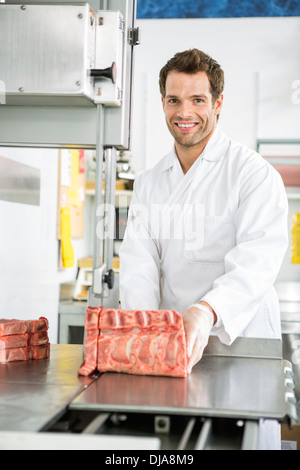 Butcher il taglio di carne a fette sulla segatrice a nastro Foto Stock