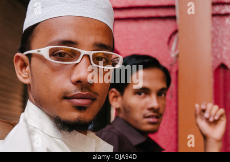 Due indiani maschio indossando abiti tradizionali a sedersi su una panchina in Deira. Dubai, Emirati Arabi Uniti. Foto Stock