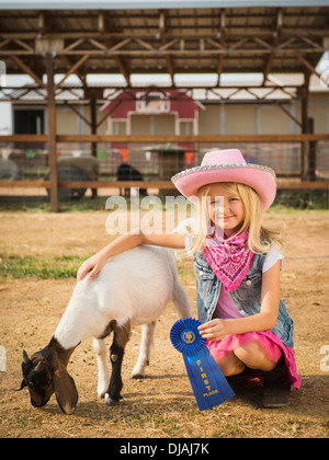 Ragazza caucasica con il vincitore del premio per capra in agriturismo Foto Stock