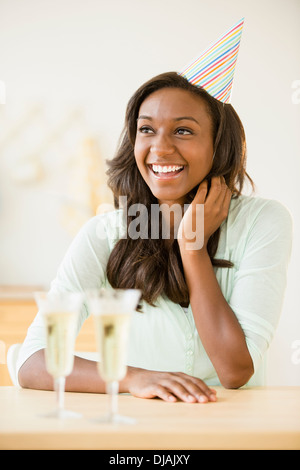 Nero donna celebrando con champagne Foto Stock