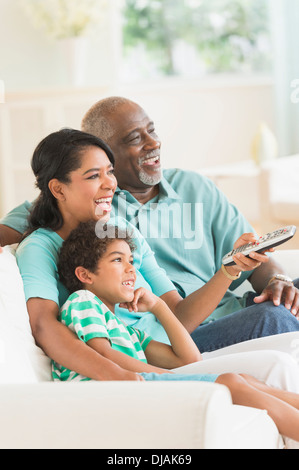 Tre generazioni di famiglie di guardare la tv Foto Stock