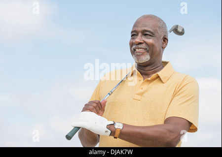 Uomo nero giocando a golf all'aperto Foto Stock