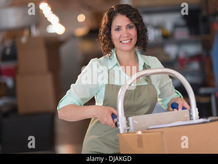 Donna ispanica lavorando in magazzino Foto Stock