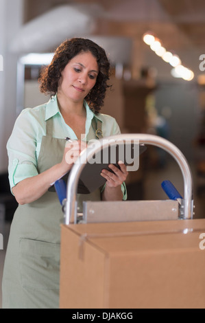 Donna ispanica lavorando in magazzino Foto Stock