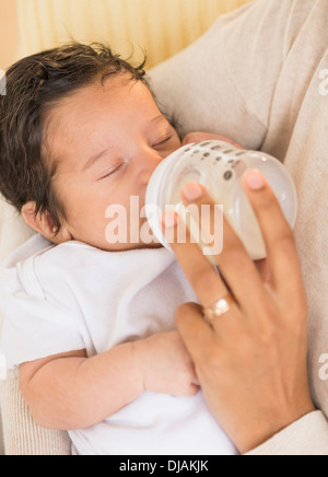 Madre ispanica alimentazione neonato Foto Stock