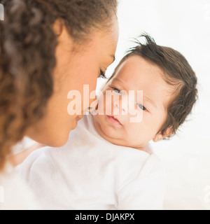 Madre ispanica nuzzling baby la guancia Foto Stock