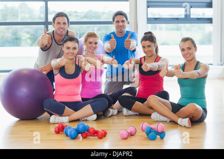 A piena lunghezza ritratto della lezione di fitness gesticolando pollice in alto Foto Stock