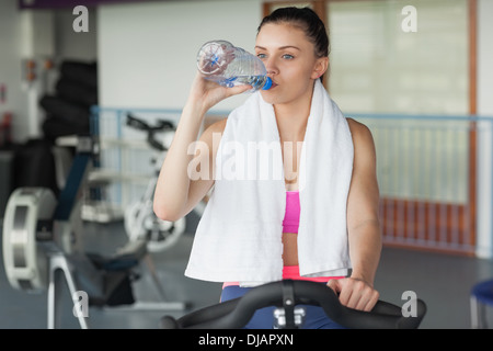 Stanco donna acqua potabile durante il lavoro in classe di filatura Foto Stock