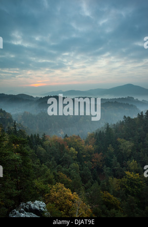 Alberi e la gamma della montagna contro il cielo nuvoloso Foto Stock