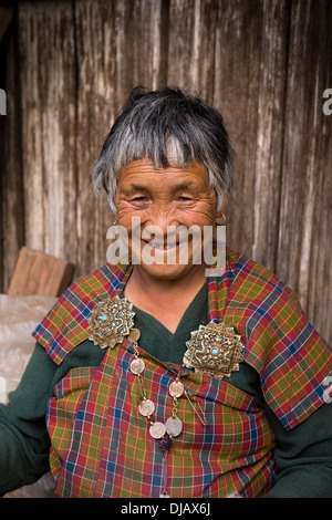 Il Bhutan, Nobding, sorridente vecchia donna nel tradizionale kira con argento vecchio korma spilla Foto Stock