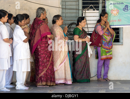 Indian medici e infermieri studente offrono le preghiere del mattino presso Sri Sathya Sai Baba mobile ospedale outreach. Andhra Pradesh, India Foto Stock