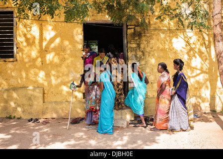 Le donne indiane i pazienti a camminare verso una clinica al Sri Sathya Sai Baba mobile ospedale outreach. Andhra Pradesh, Indiae Foto Stock