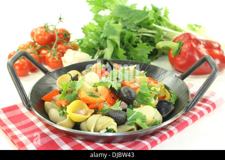 Pentola per la pasta con i peperoni e le cime di rapa su uno sfondo luminoso Foto Stock