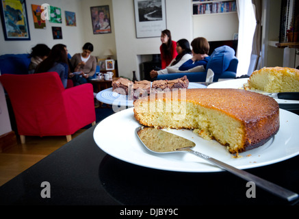 Il gruppo di donne godendo di una mattina caffè con dolci fatti in casa in primo piano Foto Stock