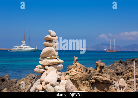 Figure in pietra sulla spiaggia a riva della spiaggia di Illetes a Formentera Mediterraneo isole baleari Foto Stock