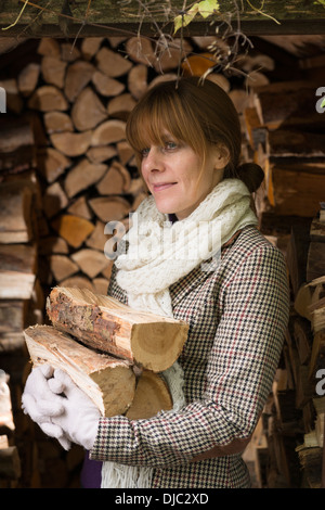 Una donna a raccogliere i log per un incendio Foto Stock