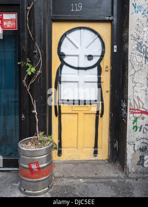 Arte di strada su di una porta da parte di un artista in Stik in corrispondenza della giunzione di Bethnal Green Road e Redchurch Street, Londra Foto Stock