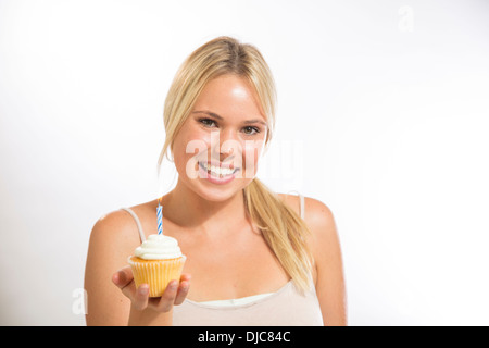 Giovane donna tenendo una tortina di compleanno Foto Stock