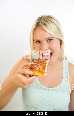 Giovane donna di mangiare la pizza Foto Stock