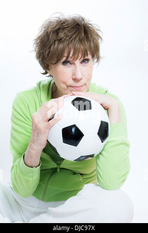 Donna matura tenendo palla calcio Foto Stock