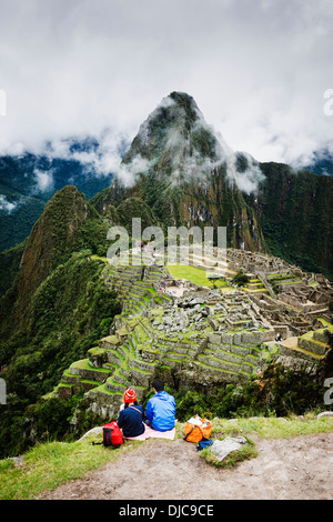 Un giovane godendo la vista della antica città Inca di Machu Picchu nella regione di Cuzco del Perù. Foto Stock