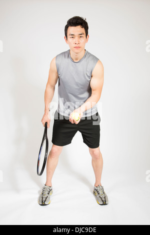 Maschio atletico holding tennis Racchetta e sfera Foto Stock